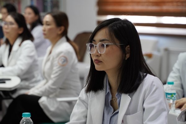 Doctor sitting with other doctors learning at a seminar