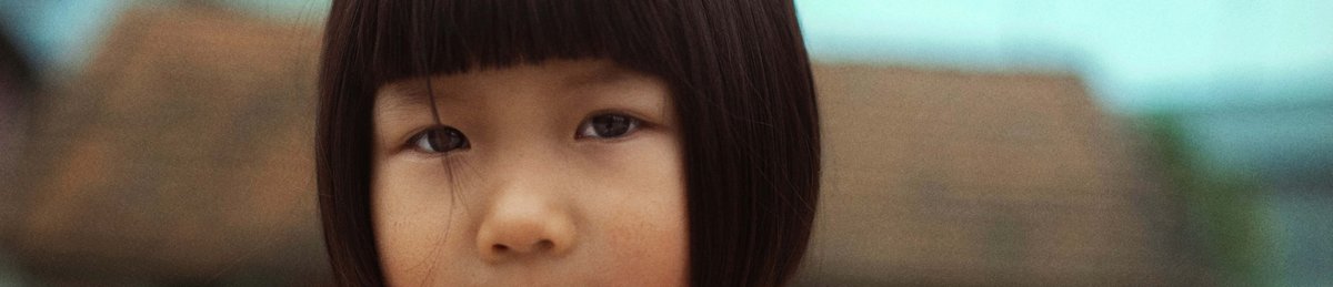 A young Asian girl, looking seriously at the camera.
